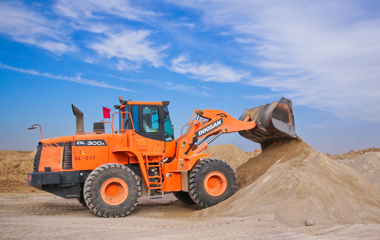 Mastering the First Impression: Your intriguing post title goes here 3 An orange bulldozer at work, moving sand under a clear blue sky on a construction site.