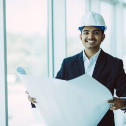 Indian Architect or engineer at work on a building site.